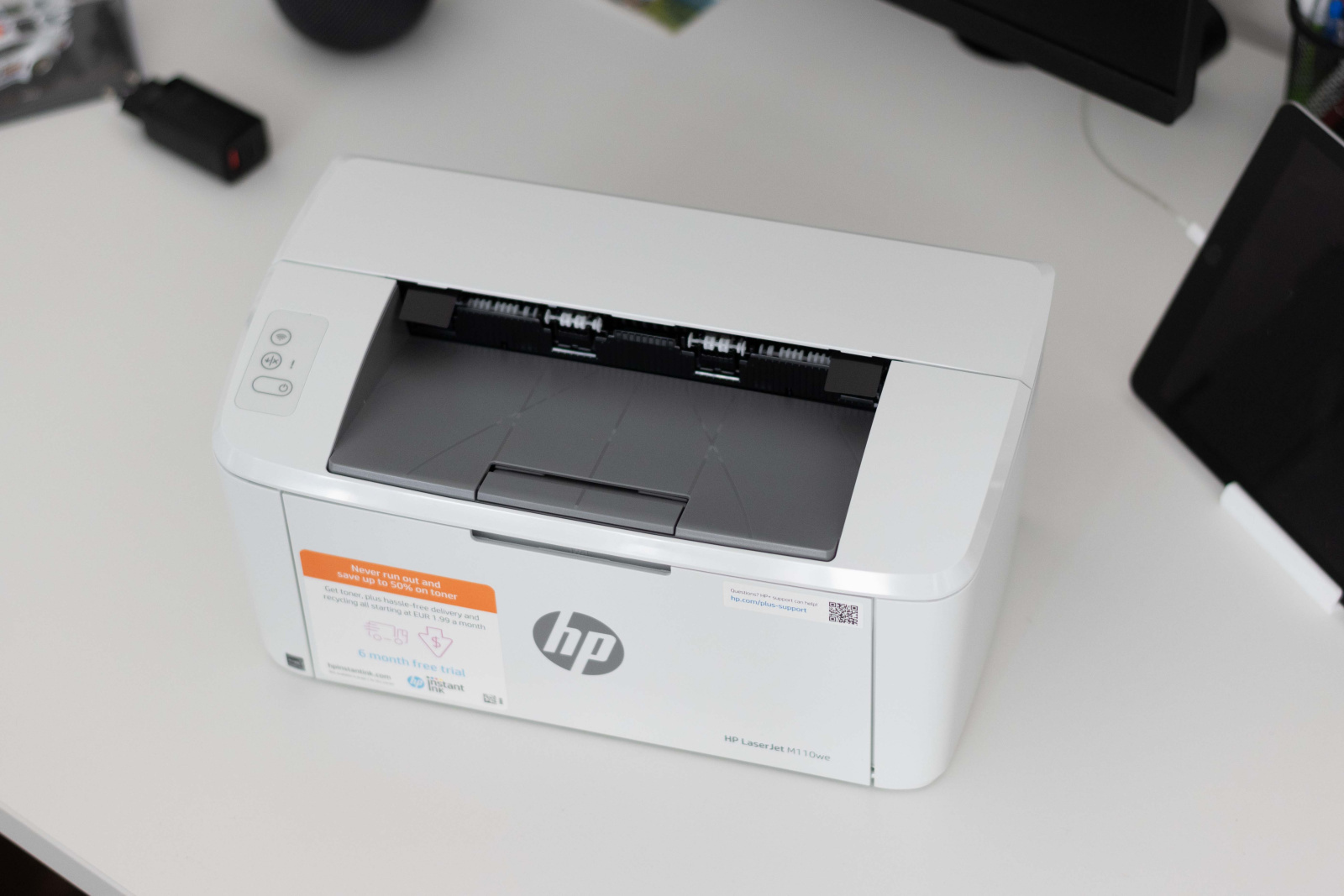 printer HP LaserJet M110we odozgo na uredskom stolu.